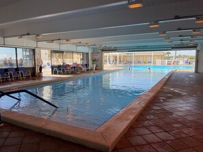 Relax by the pool surrounded by lounge chairs and umbrellas.