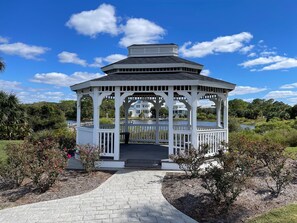 Stroll through the serene garden to this classic gazebo, surrounded by lush greenery and a tranquil body of water.