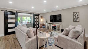 Un salon moderne avec un canapé, une table basse et un téléviseur.