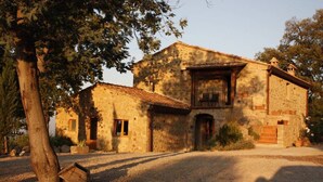 A stone building with a tiled roof, a balcony, and a gravel driveway. - Panoramic Sea Views Immersed in Nature Quiet Peaceful Private Villa Retreat (Toscana)