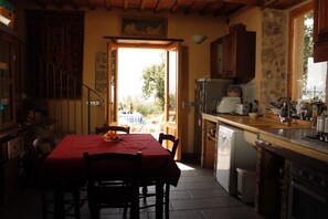 Une cuisine équipée d’une table à manger, de chaises, d’un réfrigérateur et d’un évier.