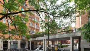 A multi-story building with balconies, a covered entrance, and parked bicycles and scooters. - GuestHost - Renovated studio apartment with all amenities! (Milano)