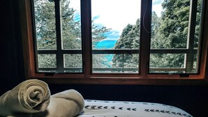 Uma janela com vista para árvores e montanhas.