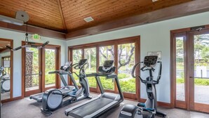 A gym with treadmills, ellipticals, and a stationary bike, large windows, and an exit sign. - Bright & quiet 2 bedroom in Kulalani, sleeps 6 (Kamuela)