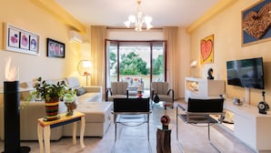 A modern living room with a sofa, two armchairs, a coffee table, a TV, and artwork on the walls. - Art Beds & Garden 9 beds between the sea, thermal baths, and the Tuscan countrys (Suvereto)
