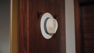 A hat hanging on a wooden wall with two hooks.