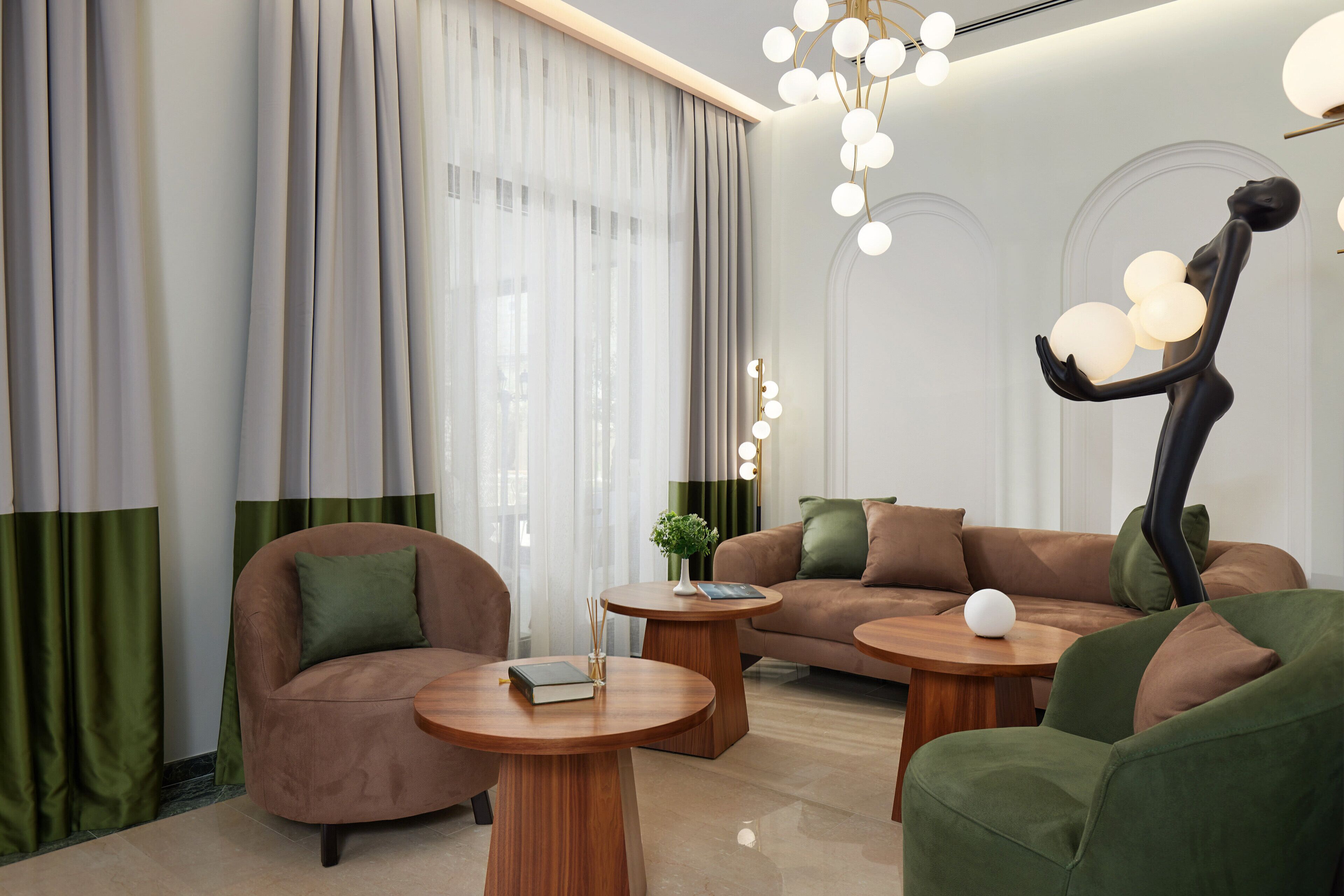 A modern living room with a sofa, two armchairs, a coffee table, and a decorative sculpture.