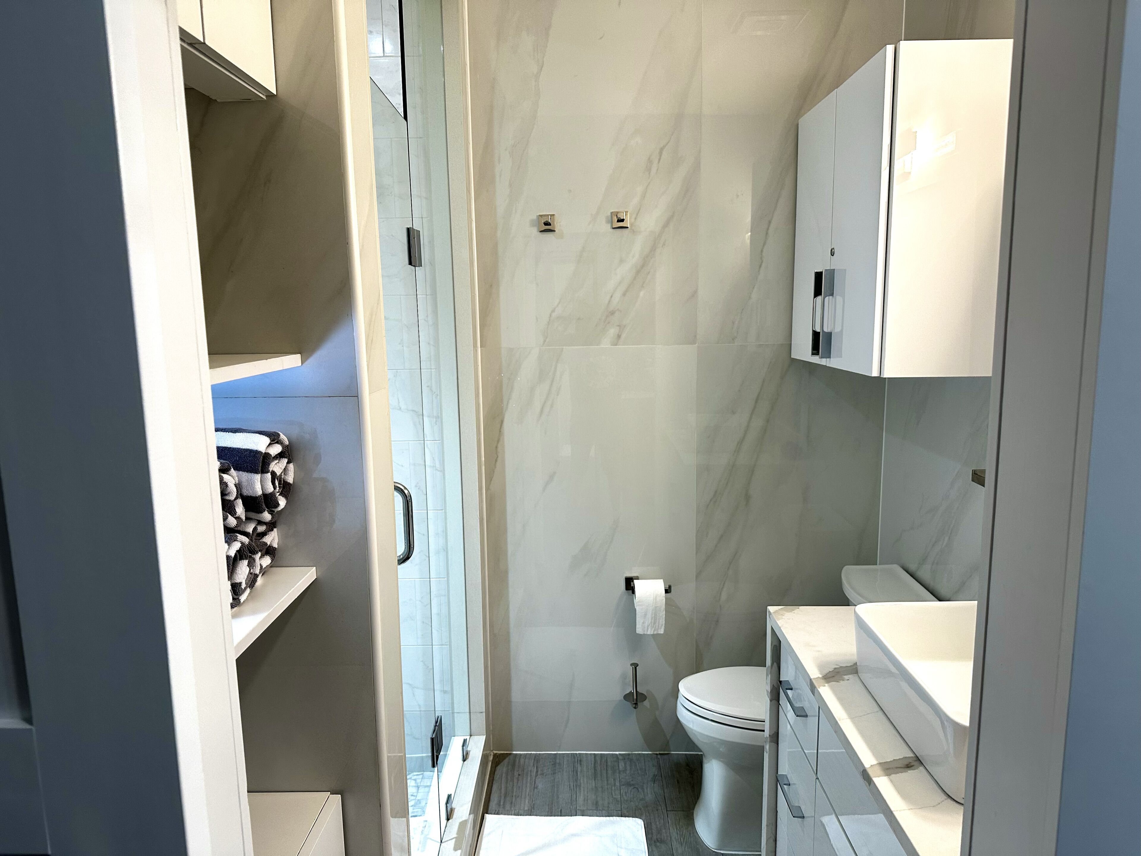 A modern bathroom with a toilet, sink, and towel rack.