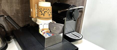 A coffee machine with a paper cup holder, a coffee grinder, and a coffee maker.