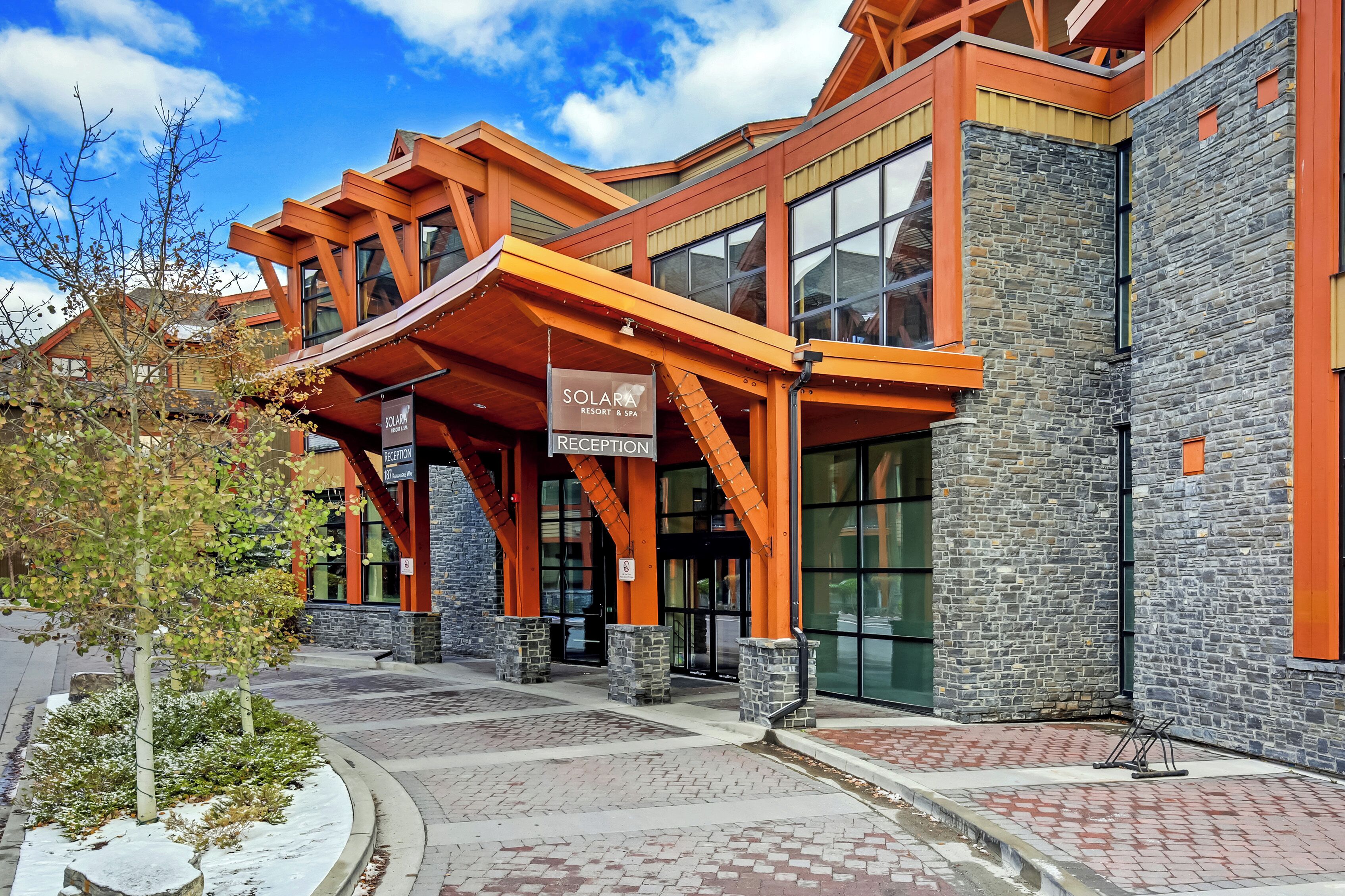 A modern building with a reception area, stone facade, and wooden beams.