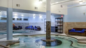 A spa area with a hot tub, lounge chairs, and a reception desk. - Bow 119 | Adorable Suite with Pool & Hot Tub (Canmore)