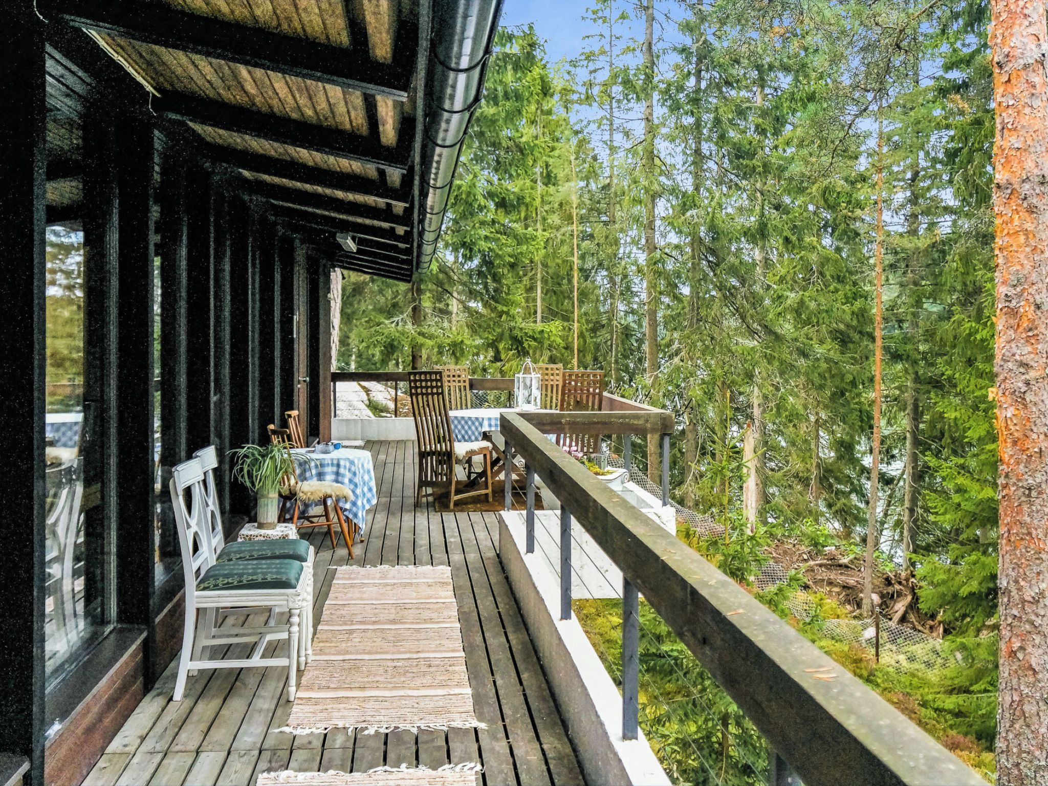 Une terrasse en bois avec des meubles d’extérieur, une table et des chaises.