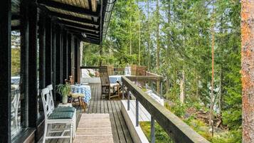 Une terrasse en bois avec des meubles d’extérieur, une table et des chaises.