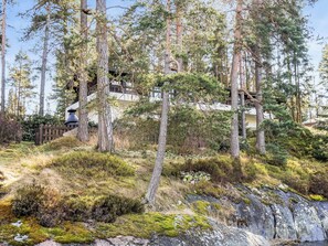 A forested area with a wooden staircase leading up to a building. - Pippuriranta by Interhome (Sipoo)