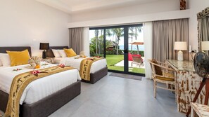 A hotel room with two beds, a desk, and a view of the outdoors.