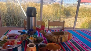 Et morgenbord med forskellig slags mad, en termokande og en flettet kurv.