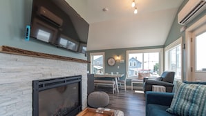 A living room with a fireplace, a sofa, and a dining area with a table and chairs.