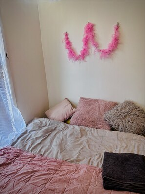 Cozy retreat with a neatly made bed, featuring a quilted bedspread and plush pillows.