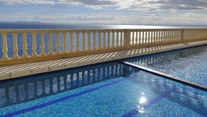 A swimming pool with a clear view of the sea and distant mountains. - VACATION ON THE ROCKS, 1ST LINE OF SEA, PRIVILEGED AREA, SEA VIEW. (Roses)