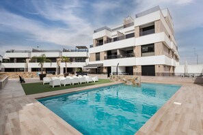 Ein modernes Hotel mit Schwimmbad, Außenbereich und einer Steinwand.