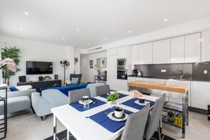 Een moderne keuken met witte kasten, een houten aanrecht en een ingebouwde oven.