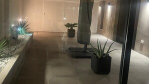 Ein modernes Interieur mit Glastrennwand, Topfpflanzen und minimalistischem Design.