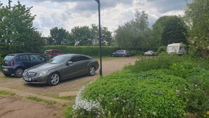 Ein Parkplatz mit mehreren Autos und einem Wohnwagen.
