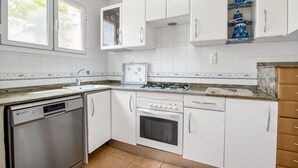 A kitchen with white cabinets, a dishwasher, an oven, and a stove.