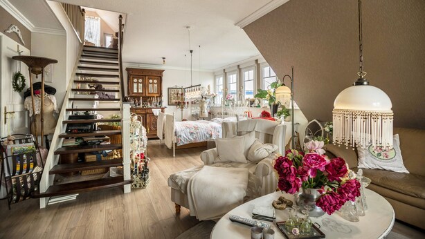 A spacious living area with a staircase, a round coffee table, and a sofa.