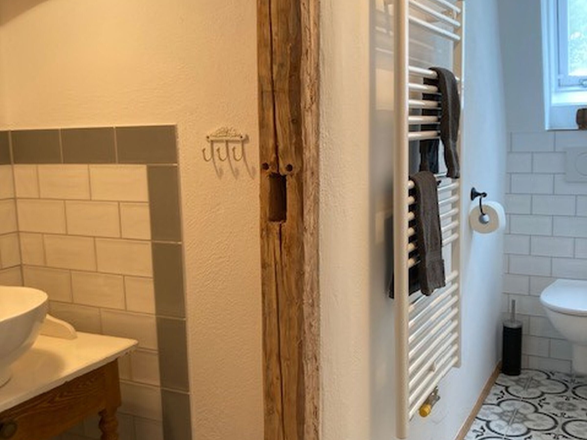 A bathroom with a white sink, a towel rack, and a toilet.