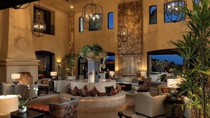 A spacious lobby with a central fountain, comfortable seating areas, and a large window overlooking the outdoors. - Grand Solmar Resorts (Cabo San Lucas)