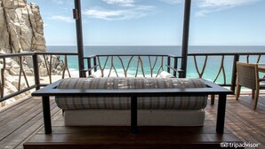 A wooden deck with a cushioned bench overlooking a rocky coastline and the ocean. - Grand Solmar Resorts (Cabo San Lucas)