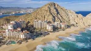 A coastal resort with multiple hotel buildings, a beach, and a mountain in the background. - Grand Solmar Resorts (Cabo San Lucas)