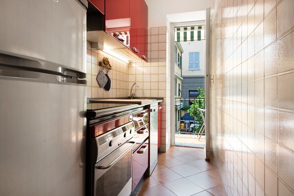 Una cocina con nevera de acero inoxidable, horno y lavaplatos.