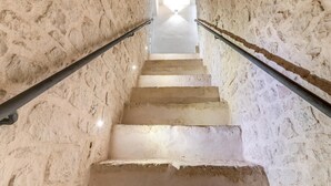 Una escalera de piedra con barandillas de metal que conduce a un espacio amplio y luminoso.