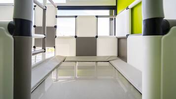 A modern, minimalist room with a bunk bed, a window with a view, and a green accent wall.