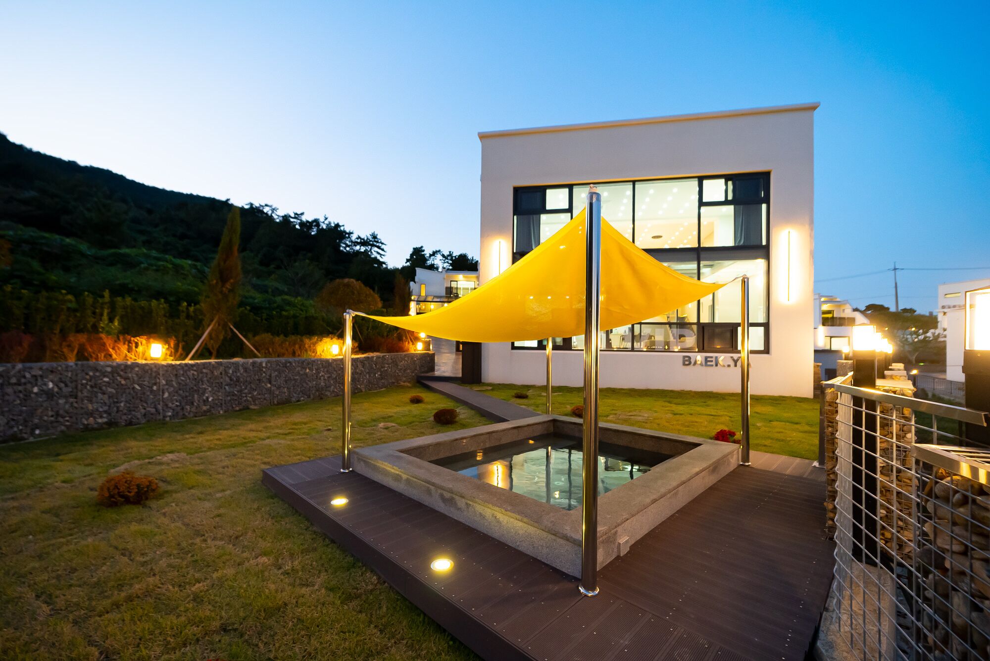 A modern building with a pool and outdoor lighting.