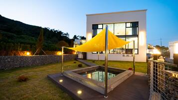 A modern building with a pool and outdoor lighting.