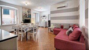 A compact living space with a dining area, a sofa, and a kitchenette. - Apartment 'Oceane Paradise - Churchill' with Sea View, Balcony and Wi-Fi (Levanto)