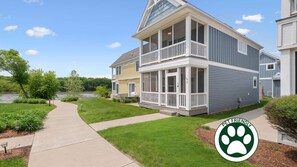 A two-story building with a covered porch, a view of a lake, and a 'PET FRIENDLY' sign.