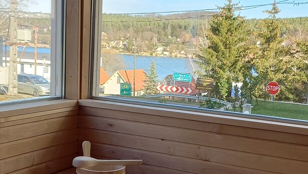 A wooden sauna room with a bench and a wooden bucket. - Apartment with panoramic lake view, sauna, close to hiking trails. (Orfu)