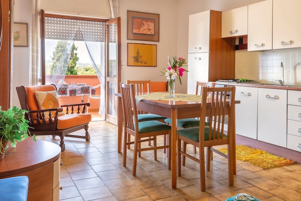 A dining area with a table, chairs, and a view through a door.