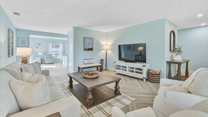 A living room with a sofa set, a coffee table, a TV, and a lamp. - Private Pool Retreat Near Anna Maria Island -Spa - Optional Pool Chiller-EV Charger (Bradenton)