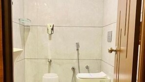 A small, modern bathroom with a toilet, bidet, and bathtub. - PPH Living Gnr Grand Luxury Rooms (Madanapalle)