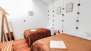 A bedroom with two beds, a wooden ladder, and wall decorations. - COZY HOME CUSCO (Cusco)