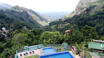 Relax by the resort's pool surrounded by lush greenery and take in breathtaking views of the valley below.
