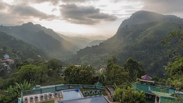 Ein Resort mit Schwimmbad, Liegestühlen und Blick auf die umliegenden Berge.