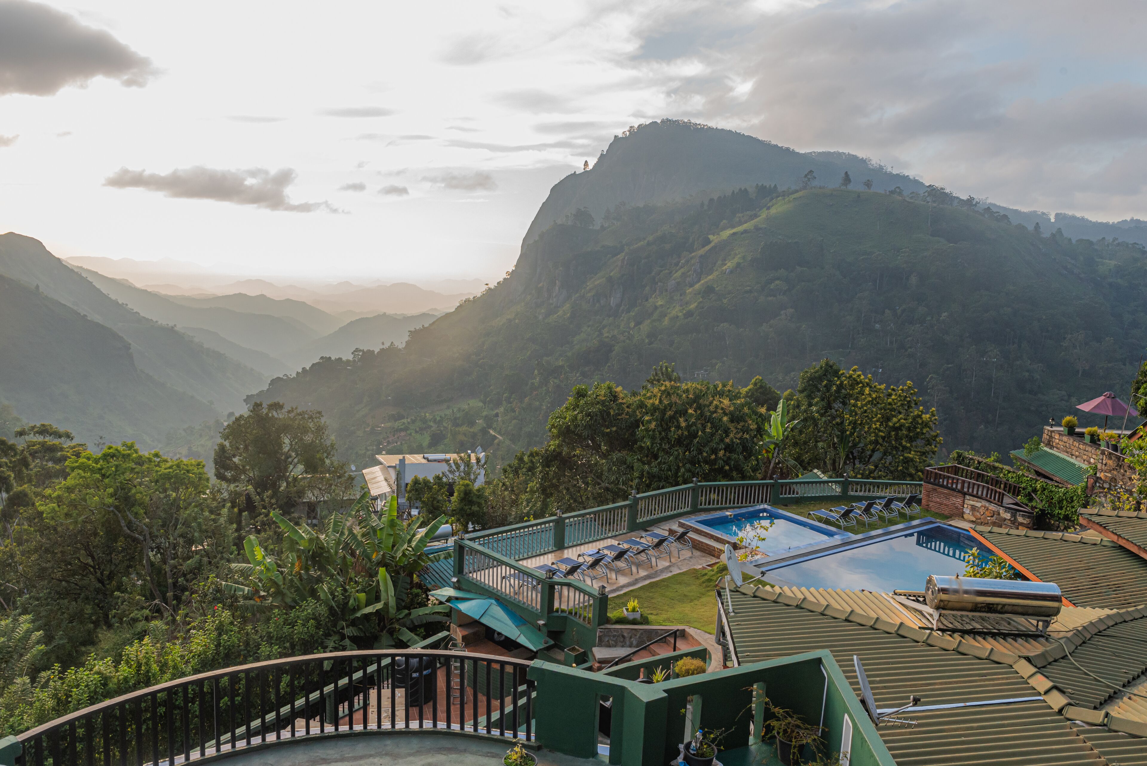 Un resort con piscina, sillas de descanso y vistas a las montañas circundantes.