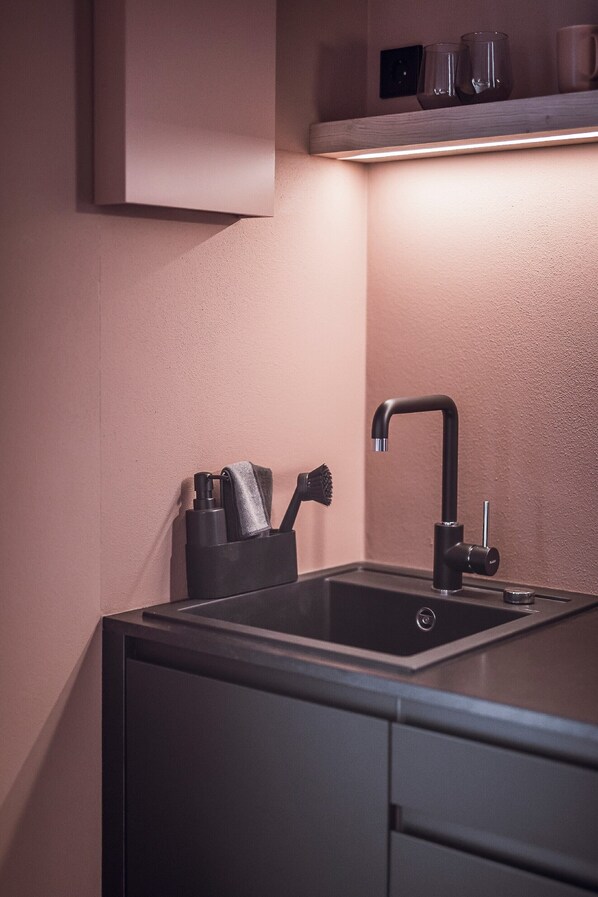 A kitchen with a modern sink, a towel holder, and a shelf above the sink. - Rousa Little Guesthouse Cosy Plus – Breakfast Included! (Rasun Anterselva)