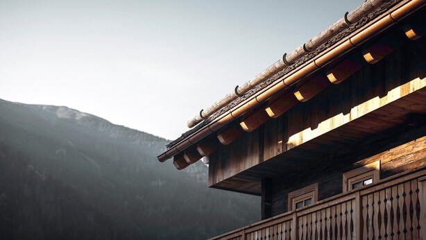 Un edificio tradicional de madera con techo inclinado y un balcón con barandilla.